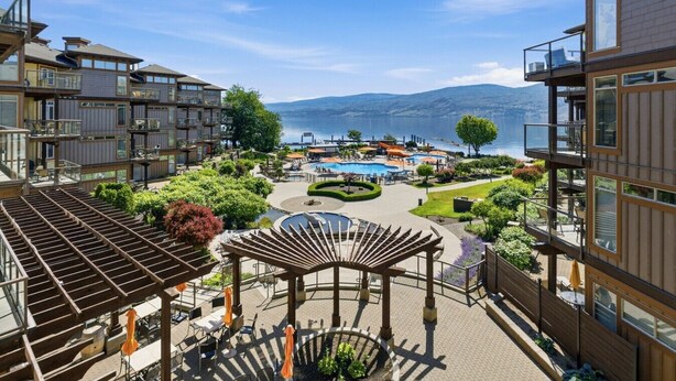 A modern hotel with outdoor pools, a gazebo, and a view of the lake.