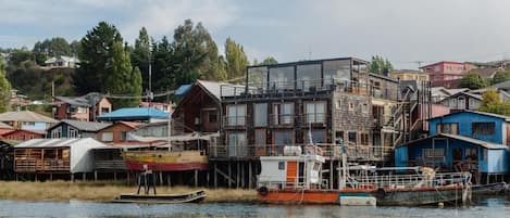 Una propiedad frente al agua con un edificio moderno, barcos y cisnes.