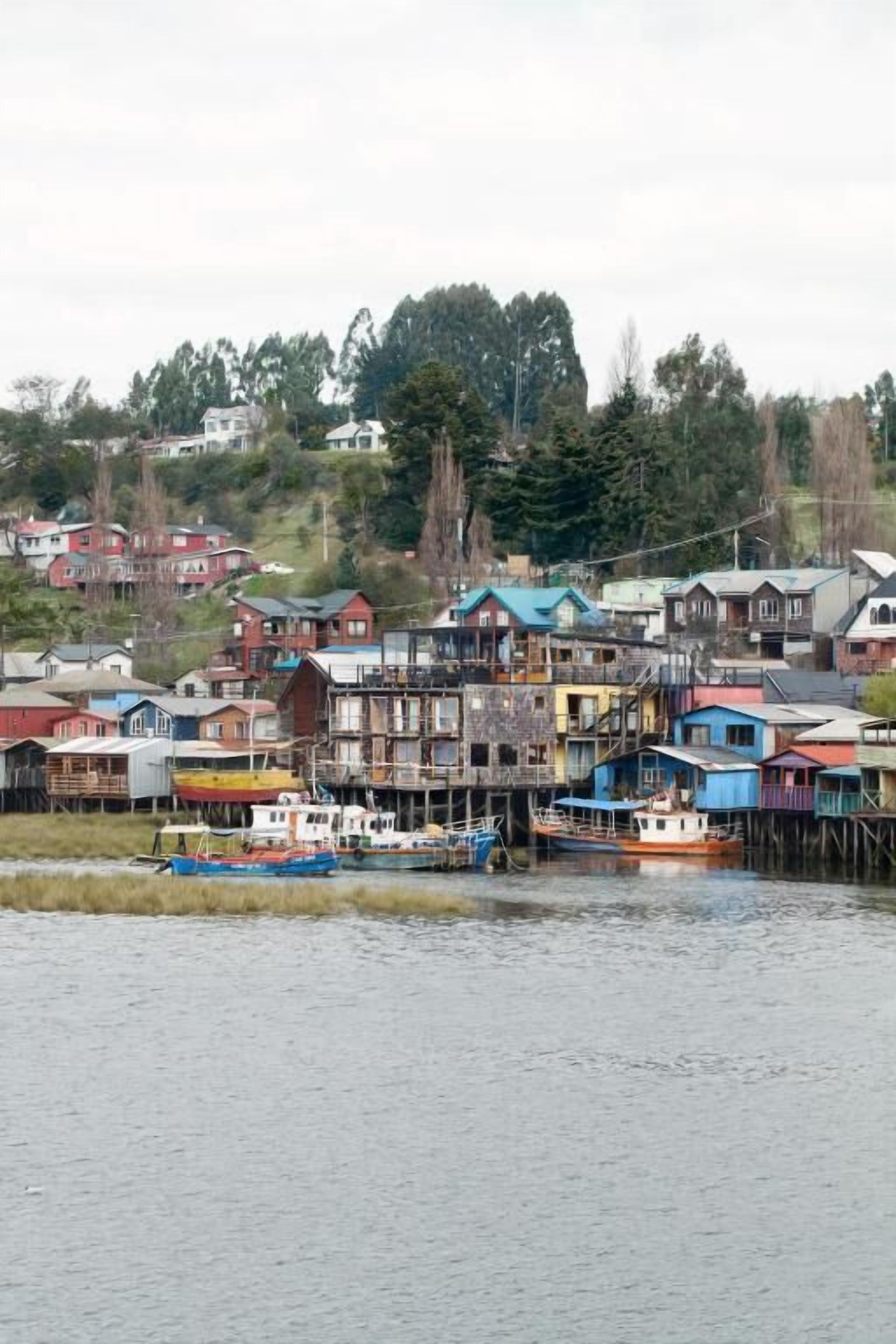 Una comunidad frente al mar, con casas de varios pisos y barcos amarrados.