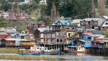 Una comunidad frente al mar, con casas de varios pisos y barcos amarrados.