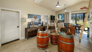 A spacious living room with a fireplace, a television, and a large window with a view. - New! Retreat with Hot Tub and Mountain Views near Bozeman! (Gallatin Gateway)