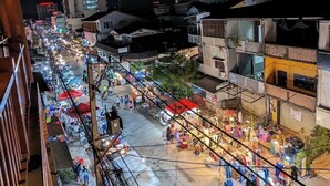 A nighttime view of a bustling street market with various stalls and buildings in the background. - Khampiane Hotel (Vientiane)