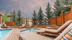 A poolside area with lounge chairs and a hot tub. - NEW LISTING | Beautiful Lodge at Mountaineer Square 2 Bedroom (Crested Butte)