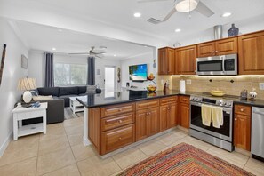 A modern kitchen with wooden cabinets, stainless steel appliances, and a large island. - BEACH HOME (Boynton Beach)