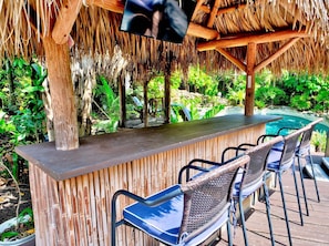 An outdoor bar area with a thatched roof, bamboo walls, and a pool. - Heated Pool/Hot Tub/10 min Beach & Airport (Fort Lauderdale)
