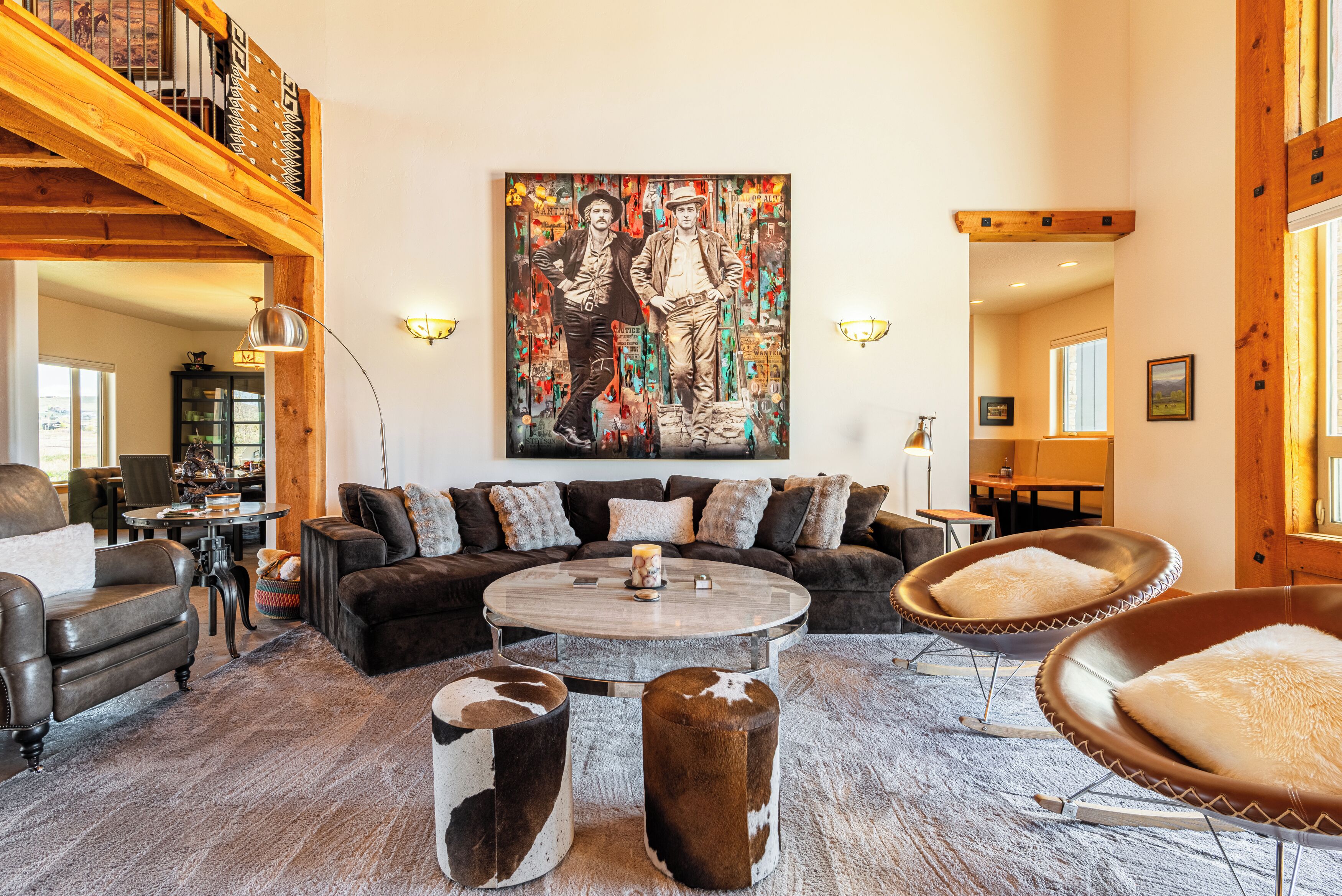 Un vaste espace de vie doté d’un haut plafond, d’un grand tableau et d’un coin salon confortable.
