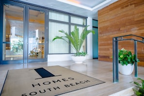A hotel entrance with a doormat, large windows, and indoor plants. - 1 Hotel South Beach,1BR/1.5BA, Beachfront Access, Balcony (Miami Beach)