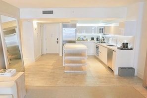 A modern kitchen with white cabinetry, a built-in oven, and a countertop with a coffee machine. - 1 Hotel South Beach-Oceanview Balcony-Resort Amenities (Miami Beach)