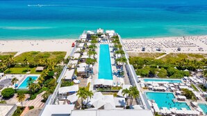 Un resort con piscina centrale, diverse piscine più piccole e una zona spiaggia.