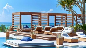 Zona junto a la piscina con sillones, una piscina pequeña y vistas al océano.