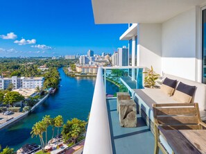 A balcony with a view of a river, city skyline, and modern building architecture. - 1 Hotel South Beach | 2BR, 14th FL Balcony, water view (Miami Beach)