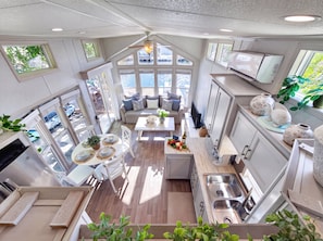 A modern kitchen with a central island, ample natural light, and a view of the outdoors. - Waterfront Tiny Home w/ Pool, Beach, Dock, Kayaks (Key Largo)
