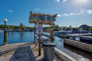 Un letrero de madera que dice 'KEY LARGO KAYAKING' y un letrero que indica 'SOLO PIEZAS DE PECES'.