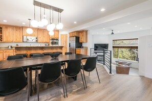 Una cocina moderna con armarios de madera, una mesa de comedor grande y sillas negras.