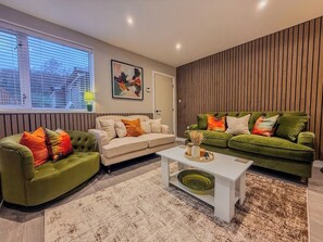 Una sala de estar moderna con un sofá, un sillón y una mesa de centro.