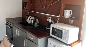 A compact kitchenette with a microwave, kettle, and coffee maker on the countertop. - KaZa Bel'Vi By La Manoshra (Capesterre de Marie-Galante)