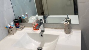 A bathroom with a large mirror, two sinks, and various toiletries. - Room-1 Spacious Bedroom Available (Papakura)