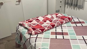 A bedroom with a bed, a nightstand, a wardrobe, and a window with curtains. - Room-1 Spacious Bedroom Available (Papakura)