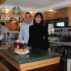 A kitchen with a bar area, a coffee machine, and a counter with food. - Hotel Verdemare (Rimini)