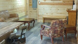 Puisesti sisustettu tila, jossa on ruokapöytä, tuoleja, sohva ja penkki.