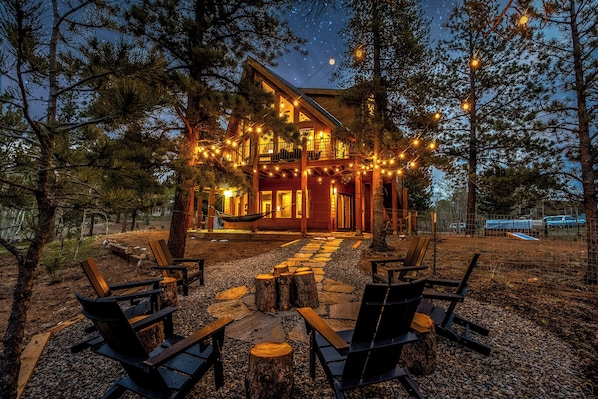 Eine Lodge mit überdachter Veranda, einer Holzterrasse und Sitzgelegenheiten im Freien.