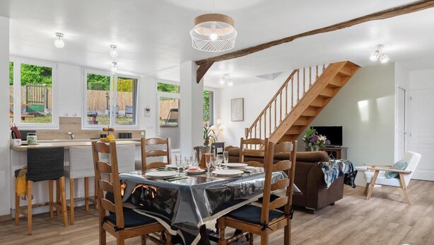 En matplats med ett bord dukat för fyra personer, trästolar, en trappa och utsikt över omgivningen.