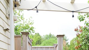 A wooden deck leading to a wooden gate, surrounded by a white fence and greenery. - Quintessential 4-bedroom farmhouse with AC in Kennebunkport (Kennebunkport)