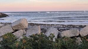 A rocky shoreline with waves, a clear sky, and some vegetation in the foreground. - Quintessential 4-bedroom farmhouse with AC in Kennebunkport (Kennebunkport)