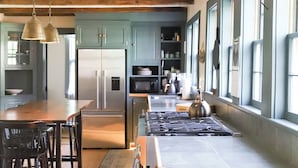 A kitchen with wooden beams, a central island, and a view to the dining area. - Quintessential 4-bedroom farmhouse with AC in Kennebunkport (Kennebunkport)