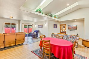 Un espacio habitable amplio con una mesa de comedor, sofás y un alto techo con tragaluces.