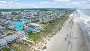 An aerial view of a coastal residential area with houses, a beach, and a swimming pool. - "Heavenly View" 5 Bedroom, 4 Bathroom, Oceanfront with Private Pool PET FRIENDLY! (Holden Beach)