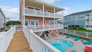 A multi-story building with a wooden deck, a pool, and outdoor seating. - "Heavenly View" 5 Bedroom, 4 Bathroom, Oceanfront with Private Pool PET FRIENDLY! (Holden Beach)