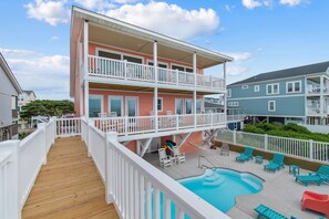 A multi-story building with a wooden deck, a pool, and outdoor seating. - "Heavenly View" 5 Bedroom, 4 Bathroom, Oceanfront with Private Pool PET FRIENDLY! (Holden Beach)