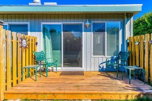 A house with a wooden deck, sliding glass doors, and outdoor furniture. - Beachfront Condo | Walk to DT | Dogs OK | Unit A (Ocean Shores)