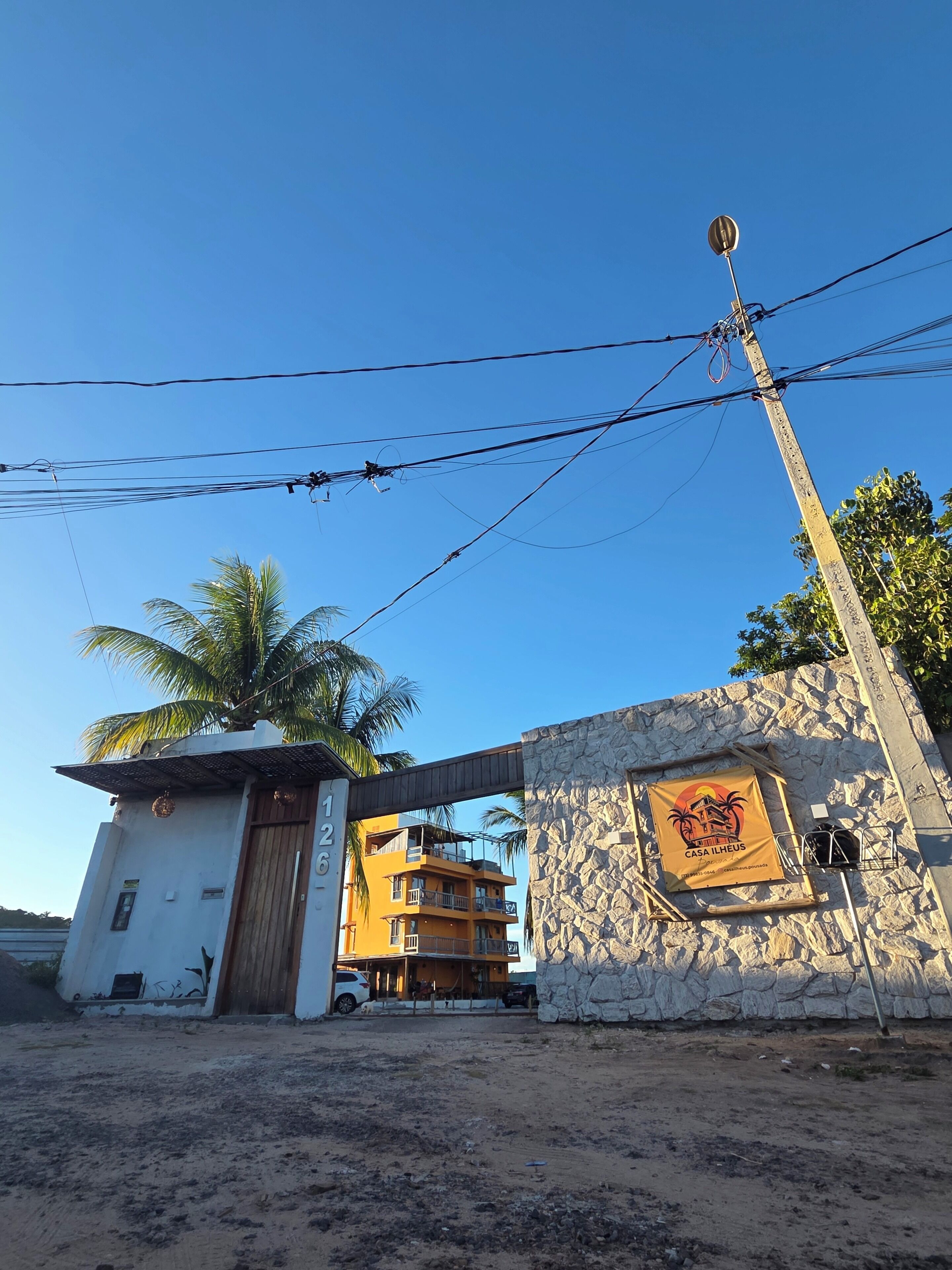 A building with a stone facade, a wooden door, and a sign with palm trees.