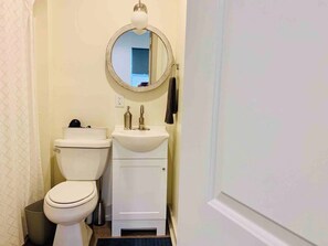Ein kleines Badezimmer mit Toilette, Waschbecken und Spiegel.
