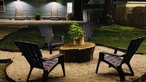 A backyard with a wooden table, two chairs, and a potted plant. - The Blue Heron-elegant urban studio in city center (Memphis)