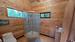 A wooden cabin bathroom with a toilet, shower, and sink. - Panoramic Mountain Views - Luxury Hilltop Retreat in Jardín de Dota (San José)