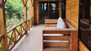A wooden cabin with a porch, wooden benches, and a view of the surrounding forest. - Panoramic Mountain Views - Luxury Hilltop Retreat in Jardín de Dota (San José)