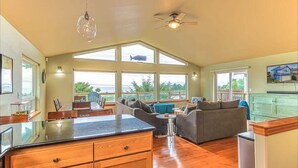 Una cocina amplia con una isla grande, una zona de comedor con sofá y un ventilador de techo.