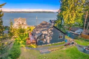 A house with a deck, a small shed, and a fire pit in the yard.