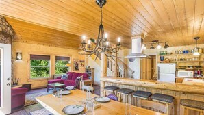 Un intérieur en bois comprenant un coin repas, une cuisine et un escalier.