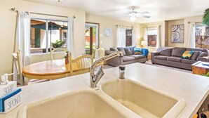 A kitchen with a double sink, a dining table, and a sofa in the living area. - Walk to Downtown | Family-Friendly Condo | Dogs OK (Leavenworth)