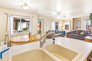 A kitchen with a double sink, a dining table, and a sofa in the living area. - Walk to Downtown | Family-Friendly Condo | Dogs OK (Leavenworth)
