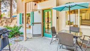 A patio with a grill, outdoor seating, and a door with a green frame. - Walk to Downtown | Family-Friendly Condo | Dogs OK (Leavenworth)