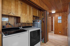 Eine kleine Küche mit Holzausstattung, einer Waschmaschine und einem Trockner.