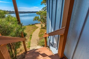 A staircase leading to a deck with a view of a lake and surrounding greenery.
