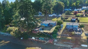 An aerial view of a residential area with houses, a dock, and a body of water. - Waterfront Haven: Beach Access, Hot Tub, Fire Pit (Shelton)