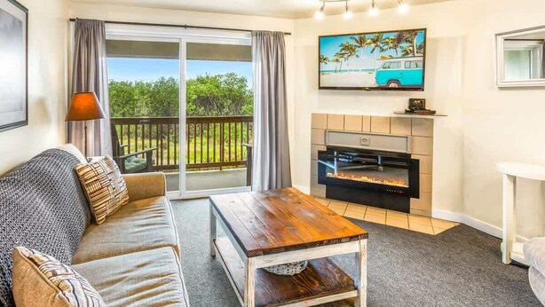 A living room with a sofa, a coffee table, a fireplace, and a television. - 1BR Condo | Dogs OK | Close to Ocean & Town (Ocean Shores)