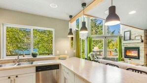 Una cocina moderna con lavavajillas, ventanas amplias y chimenea.